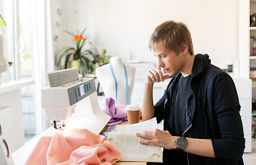 Image showing fashion designer reading book at studio