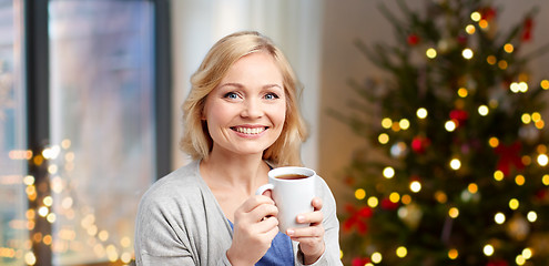 Image showing woman with cup of tea or coffee on christmas