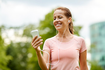 Image showing woman listening to music on smartphone at park