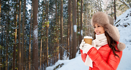 Image showing woman in fur hat with coffee over winter forest