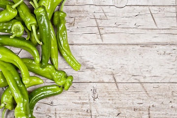 Image showing Fresh green raw peppers on rustic wooden table background. 