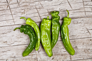 Image showing Fresh green raw peppers on rustic wooden table background. 