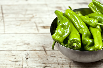 Image showing Fresh green raw peppers in metal bowl on rustic wooden table bac