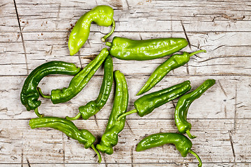 Image showing Fresh green raw peppers group on rustic wooden table background.