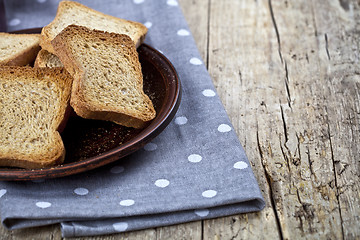 Image showing Toasted cereal bread slices on brown ceramic plate closeup on li