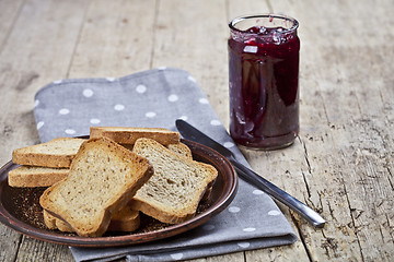 Image showing Toasted cereal bread slices on grey plate and jar with homemade 