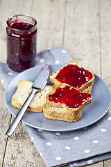 Image showing Toasted cereal bread slices on grey plate and jar with homemade 