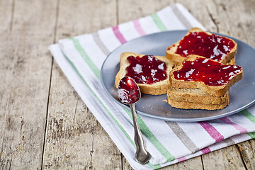 Image showing Fresh toasted cereal bread slices with homemade cherry jam and s