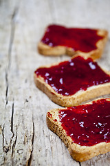 Image showing Fresh toasted cereal bread slices with homemade cherry jam close