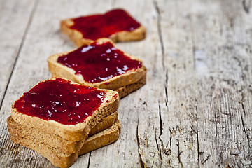 Image showing Toasted cereal bread slices with homemade cherry jam closeup on 