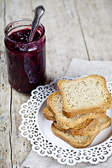 Image showing Homemade cherry jam in glassjar and fresh toasted cereal bread s