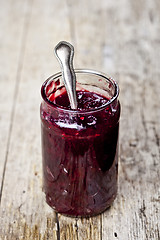 Image showing Fresh cherry homemade jam in jar on rustic wooden background.