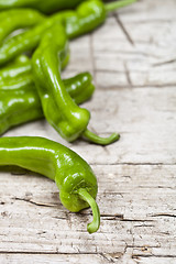 Image showing Fresh green raw peppers on rustic wooden table background. 