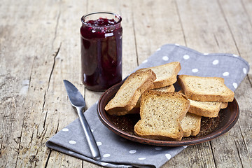 Image showing Toasted cereal bread slices on grey plate and jar with homemade 