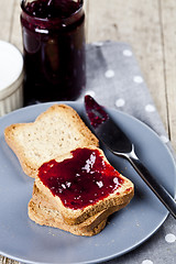 Image showing Fresh toasted cereal bread slices on grey plate and jar with hom