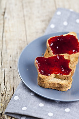 Image showing Fresh toasted cereal bread slices with homemade cherry jam on gr