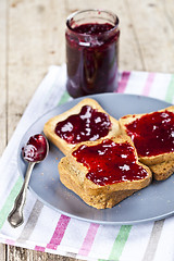 Image showing Fresh toasted cereal bread slices with homemade cherry jam in ja