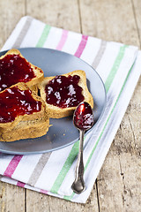 Image showing Fresh toasted cereal bread slices with homemade cherry jam and s