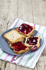 Image showing Fresh toasted cereal bread slices with homemade cherry jam and s