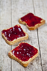 Image showing Toasted cereal bread slices with homemade cherry jam closeup on 