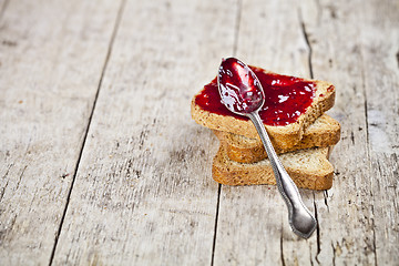 Image showing Toasted cereal bread slices stack with homemade cherry jam and s