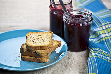 Image showing Cereal bread slices on blue ceramic plate and homemade cherry an