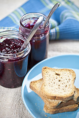 Image showing Toasted cereal bread slices on blue ceramic plate and homemade c