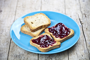 Image showing Fresh toasted cereal bread slices with homemade wild berries jam