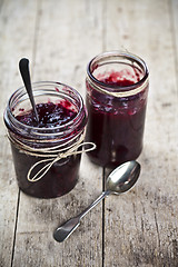 Image showing Two jars of fresh cherry and wild berries  homemade jam in jar o