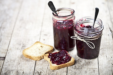 Image showing Toasted cereal bread slices and jars with homemade wild berries 