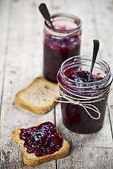 Image showing Toasted cereal bread slices and jars with homemade wild berries 