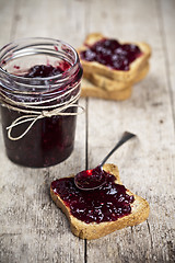 Image showing Toasted cereal bread slices and jar with homemade wild berries j