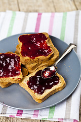 Image showing Fresh toasted cereal bread slices with homemade cherry jam and s