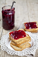 Image showing Toasted cereal bread slices on white plate and jar with homemade