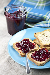 Image showing Toasted cereal bread slices on blue ceramic plate and homemade w