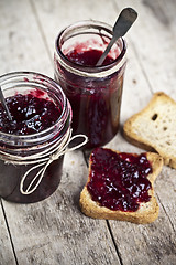 Image showing Toasted cereal bread slices and jars with homemade wild berries 