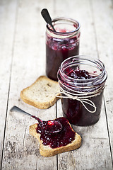 Image showing Cereal fresh bread toasts slices and jars with homemade wild ber