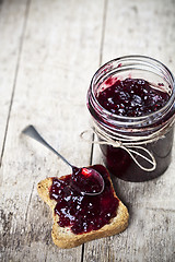 Image showing Toasted cereal bread slices and homemade wild berries jam in jar