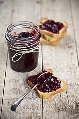 Image showing Toasted cereal bread slices and jar with homemade wild berries j