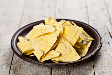 Image showing Nachos chips on brown ceramic plate. 