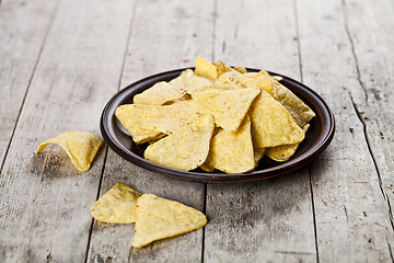 Image showing Nachos chips on brown ceramic plate.