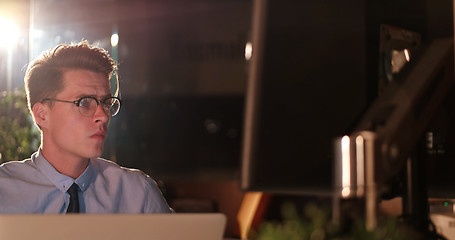 Image showing man working on computer in dark office