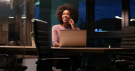 Image showing black businesswoman using a laptop in night startup office