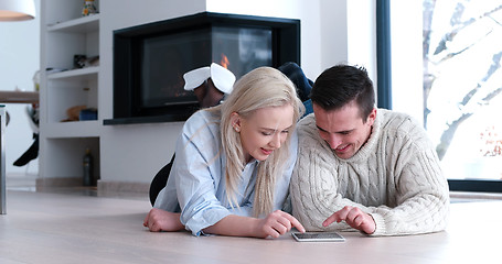 Image showing Young Couple using digital tablet on the floor