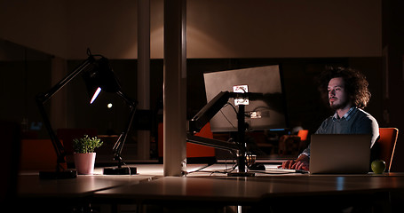 Image showing man working on computer in dark office