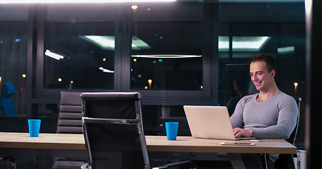 Image showing man working on laptop in dark office