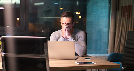 Image showing man working on laptop in dark office