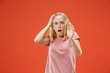 Image showing Portrait of the scared woman on red