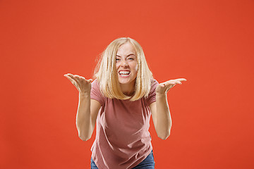 Image showing Beautiful female half-length portrait isolated on red studio backgroud. The young emotional surprised woman