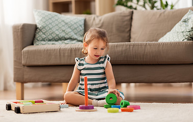 Image showing happy baby girl playing with toy blocks at home